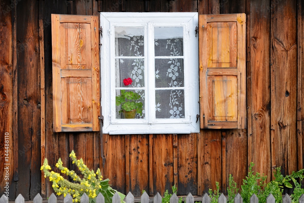 wooden window rural house with shutters and flower