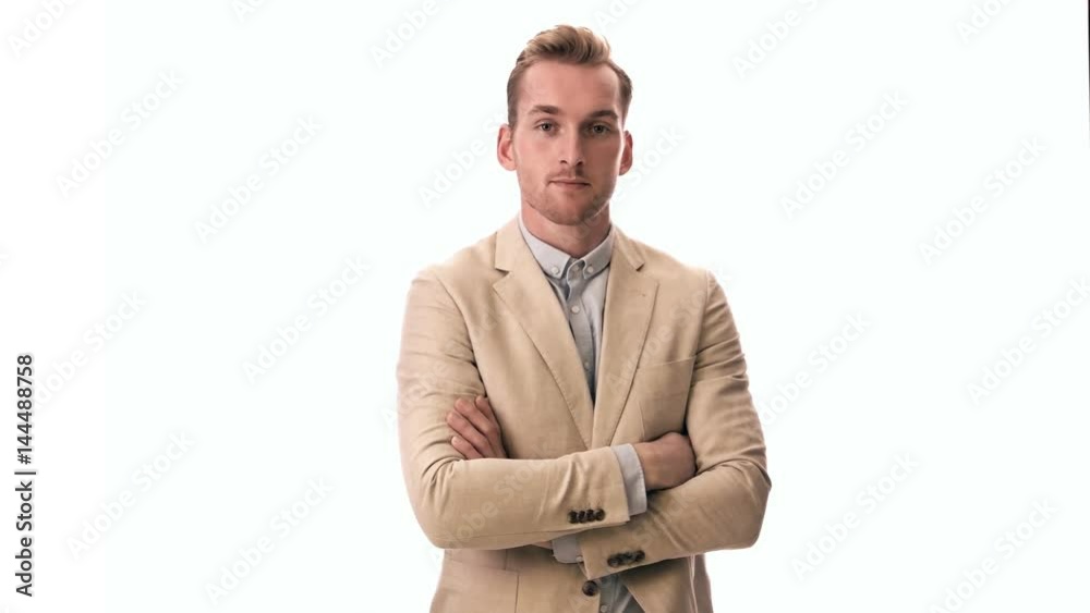 Trendy fashionable man in a bright beige suit and blue shirt standing against a white background smiling. Trendy fashionable man in a bright beige suit and blue shirt standing against a white background smiling.
