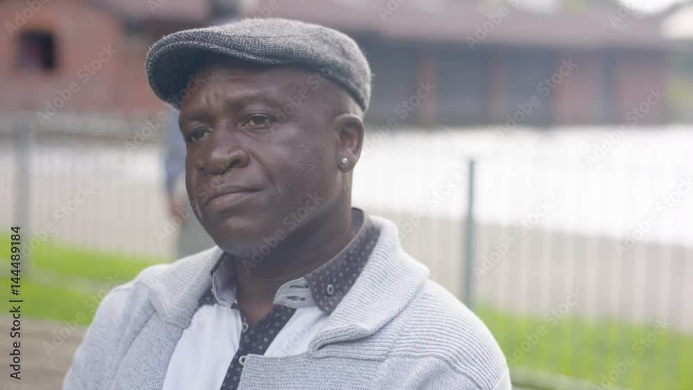  Close up portrait sad senior man sitting alone with his thoughts in the park