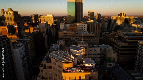 A sunset timelapse of the city centre of Johannesburg (CBD) with blue skies and shadows moving across showing the High Court of South Africa, old Sun International and Carlton Tower photo