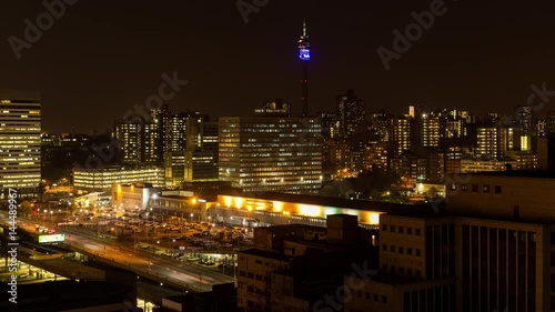 Static night timelapse of the Johannesburg Park station (Gautrain) showing the hustle and bustle of people at the train station parking area during peak traffic time after work, South Africa photo