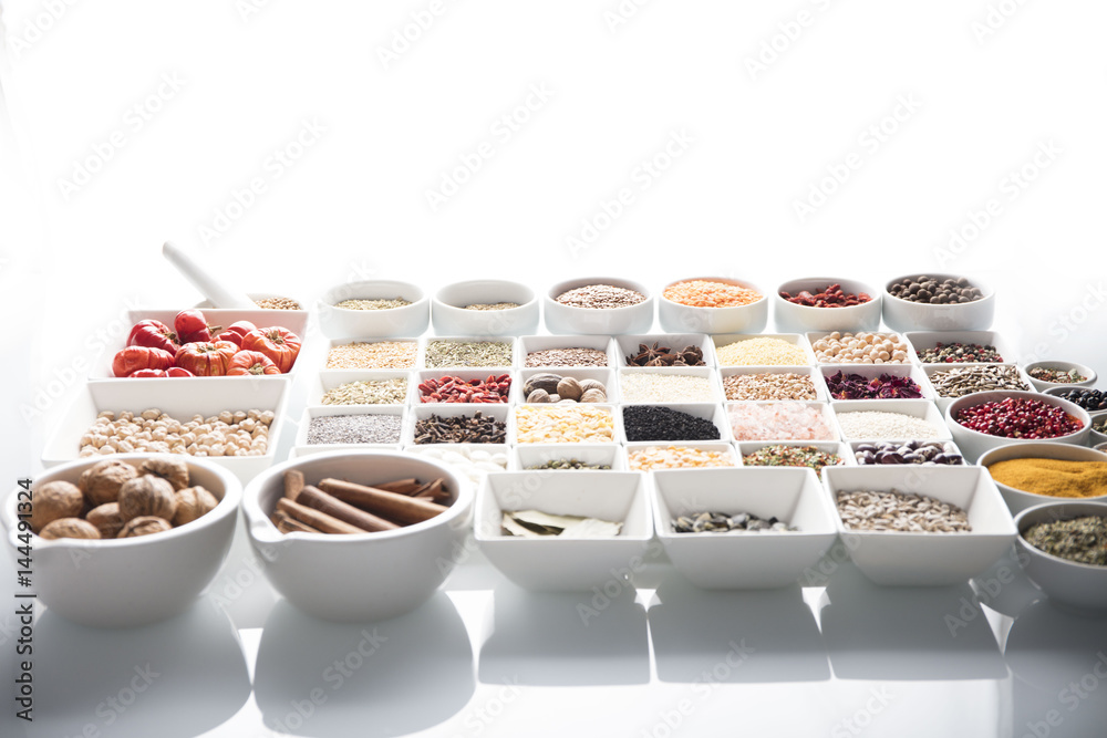 leguminous vegetables and spices in bowls, isolated on a white background