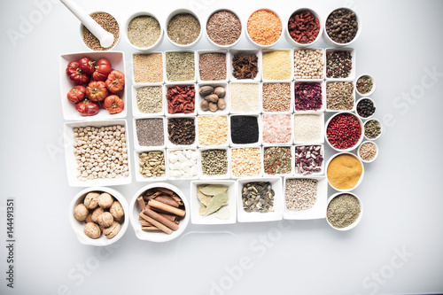 leguminous vegetables and spices in bowls, isolated on a white background