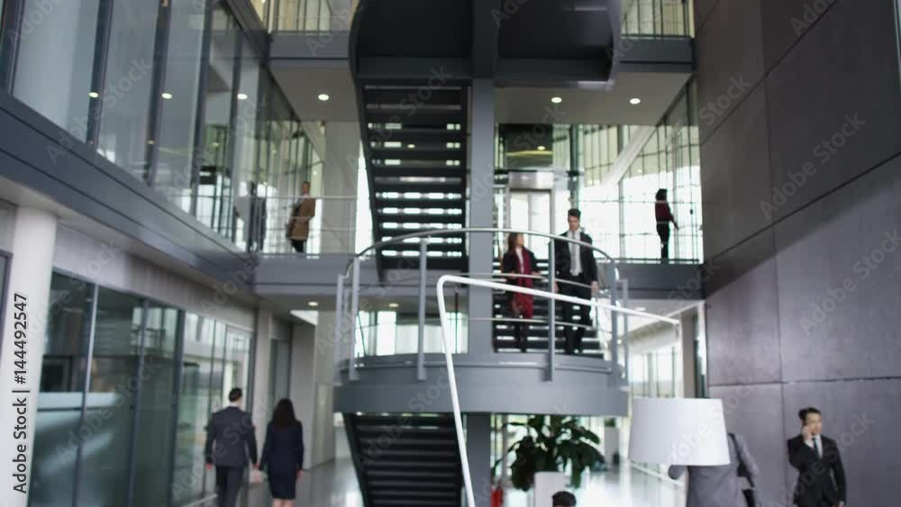  Business people meet & shake hands in large modern office building
