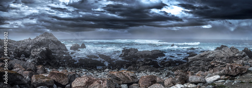 фотографія Foggy view of Pebble Beach California coast with storm clouds and rough seas causing waves to crash on rocks