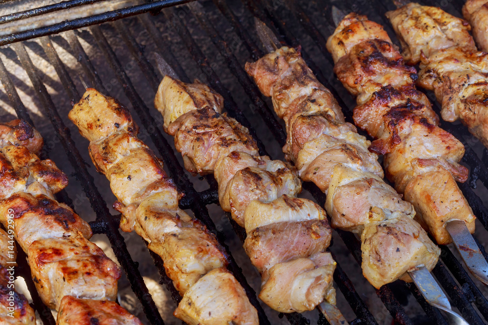 Grilled kebab cooking on metal skewer closeup. Roasted meat cooked at barbecue.