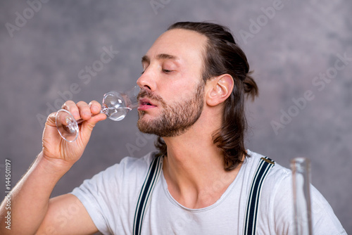 Fotografie young man drinking clear spirit