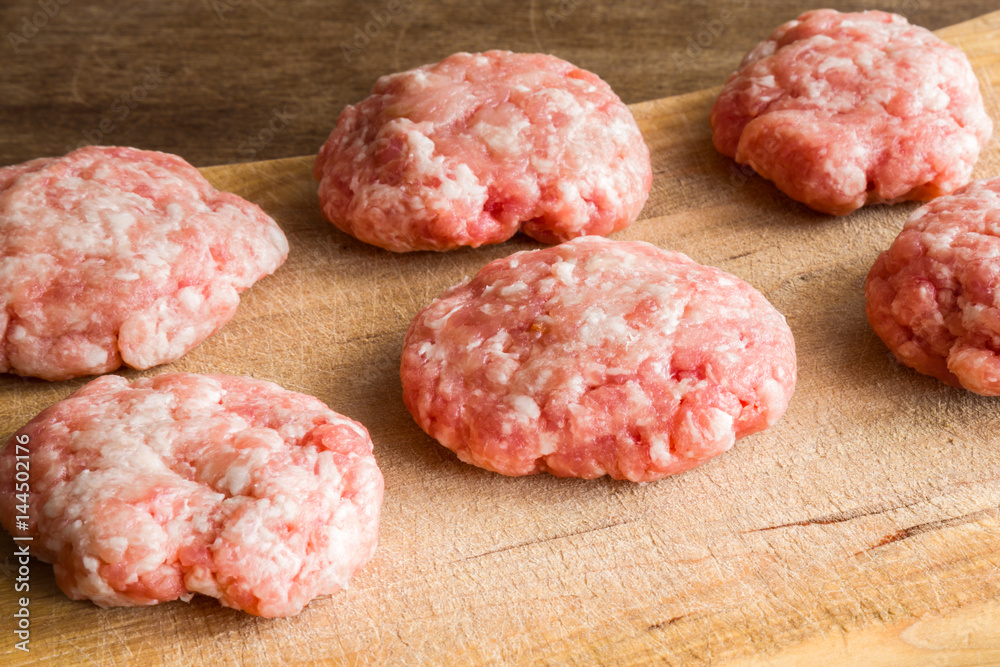 Cutlets from minced meat before baking on the wooden board in the kitchen. Healthy eating and lifestyle. Cutlets from minced meat before baking on the wooden board in the kitchen. Healthy eating and lifestyle.