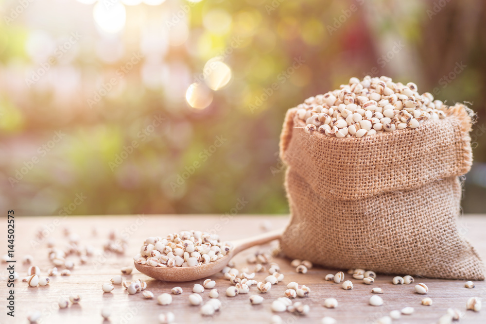 Millet rice or millet grains in small sack on wooden table. Outdoor  shooting with sunlight and blur background Stock Photo | Adobe Stock