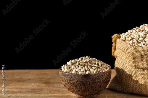 Close up millet rice or millet grains in bowl on wooden table. Isolated on black