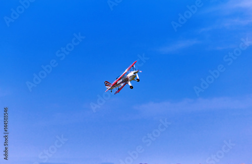 Flight of a sport aircraft against a blue sky.