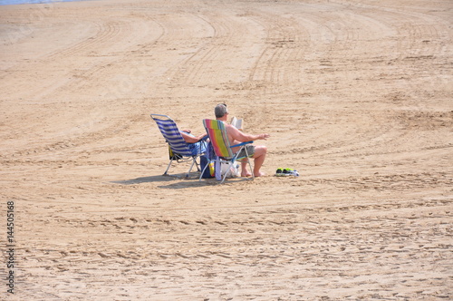 An elderly couple is resting on the Mediterranean coast in Spain
