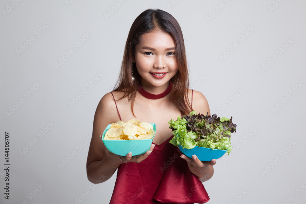 Young Asian woman with potato chips and salad. Young Asian woman with potato chips and salad.