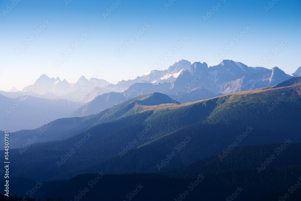 The first rays of the sun illuminate the mountain in the Western Caucasus