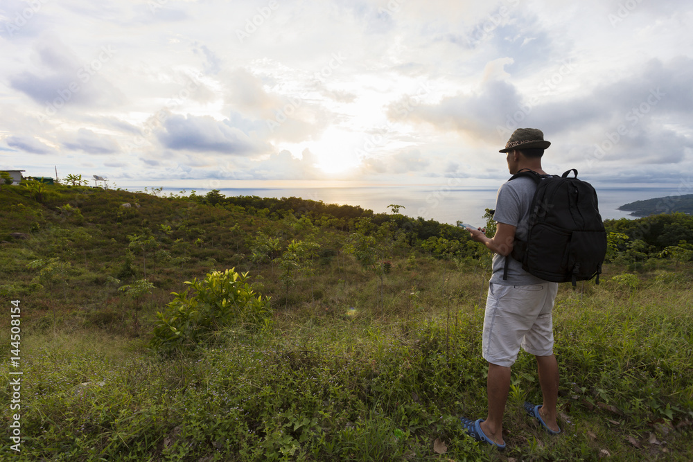 Young traveler man with backpack standing relax against landscape scenery sunset in phuket thailand. Young traveler man with backpack standing relax against landscape scenery sunset in phuket thailand.