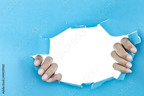 male hand ripped blue paper on white background.