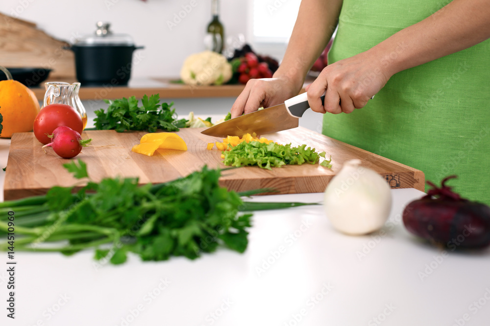 Close up of woman's hands cooking in the kitchen. Housewife slicing fresh salad. Vegetarian and healthily cooking concept Close up of woman's hands cooking in the kitchen. Housewife slicing fresh salad. Vegetarian and healthily cooking concept