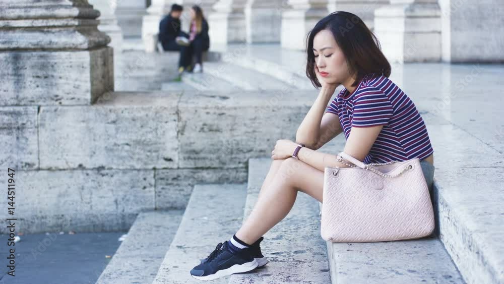 bored, pensive young Chinese woman waiting for someone bored, pensive young Chinese woman waiting for someone