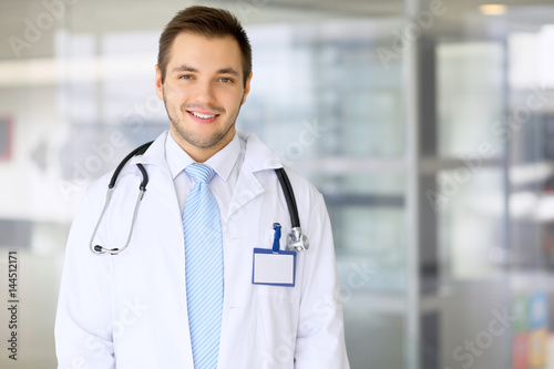 Smiling doctor waiting for his team while standing upright