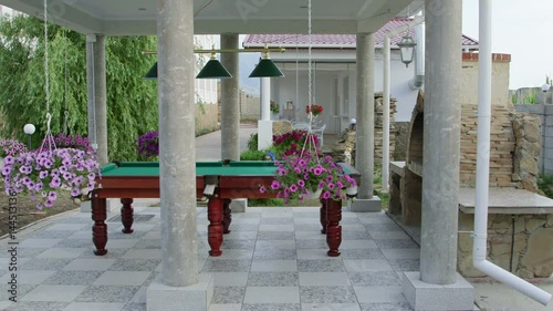 Outdoor billiard table area at back garden of a house. Two storey home with swimming pool and patio. photo