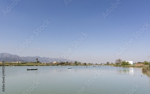 Calm lake with fishing boats. Fresh water lagoon in Estany de cullera. Valencia, Spain