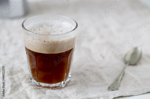 Glass of dark beer on white textile background