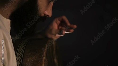 close up shot of man drumming out a beat on an arabic percussion drum named Bendir at home. Shot at counterlight. photo