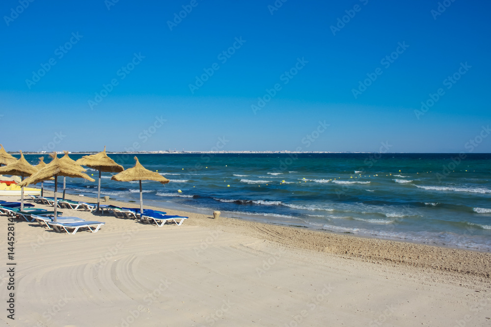 sand beach with thatched umbrellas and parasols sand beach with thatched umbrellas and parasols
