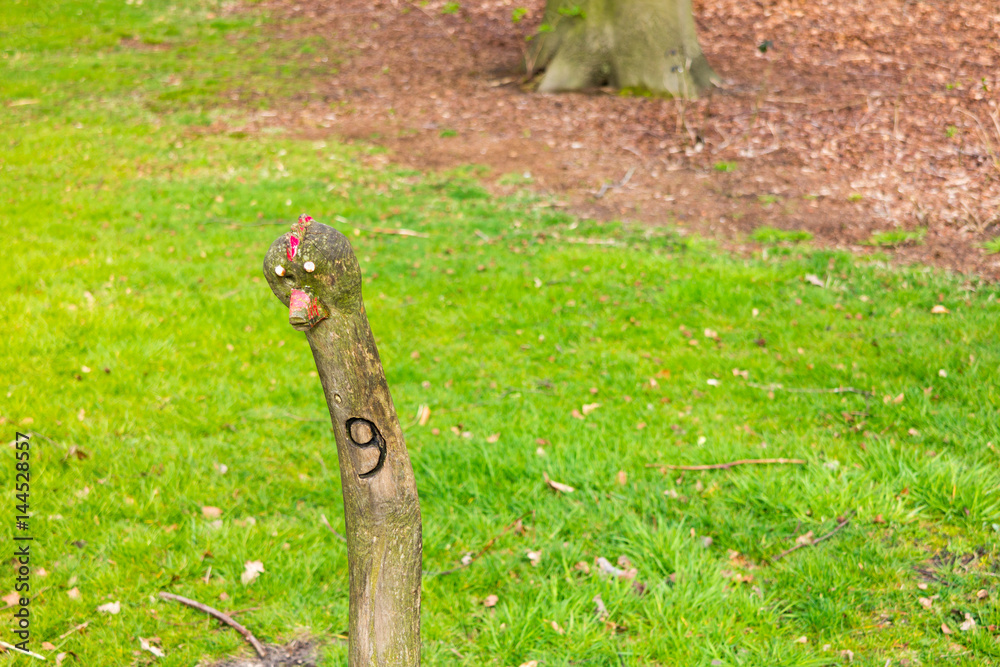 Funny wooden stick with face and number 9 marking walking route in Boekesteyn park, 's Graveland, Netherlands