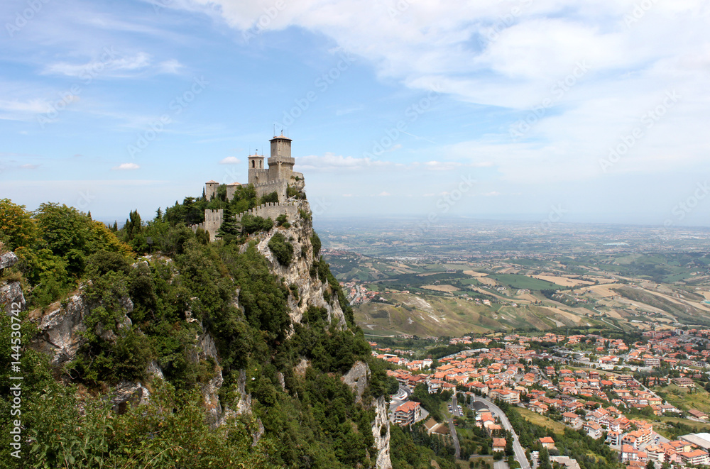 San marino. Emilia-Romagna. Castle on the rock and view of town on blue sky background, horizontal view.