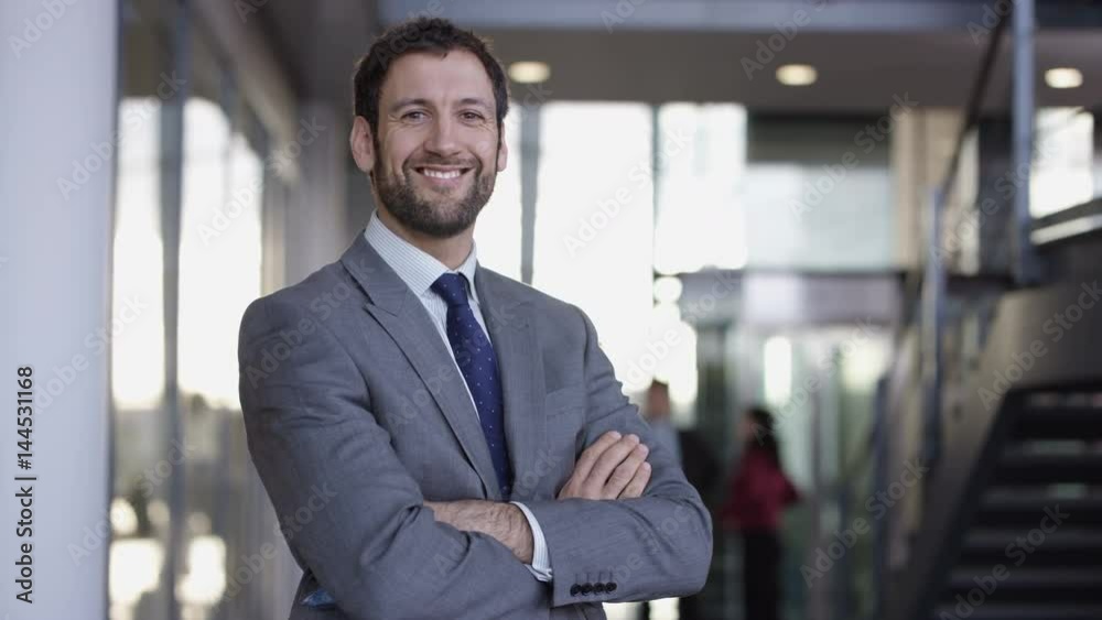 Portrait smiling successful businessman in large modern office building Portrait smiling successful businessman in large modern office building