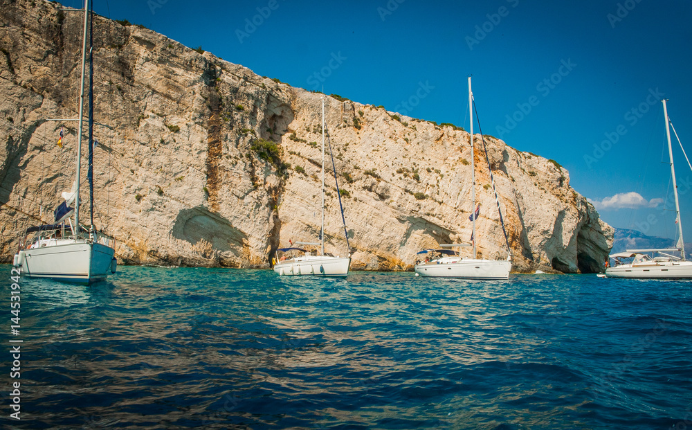 Greece, Zakynthos, August 2016. Rocks, caves and blue water, boats in harbour