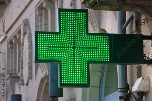 Croix verte lumineuse sur la façade d'une pharmacie photo