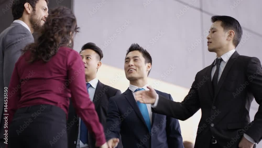 Business teams greet each other & shake hands in modern office building Business teams greet each other & shake hands in modern office building