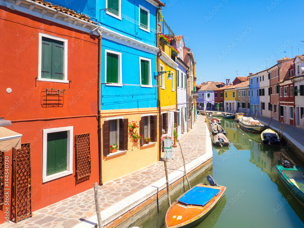 Colored houses over water canal in Burano, near Venice lagoon.
