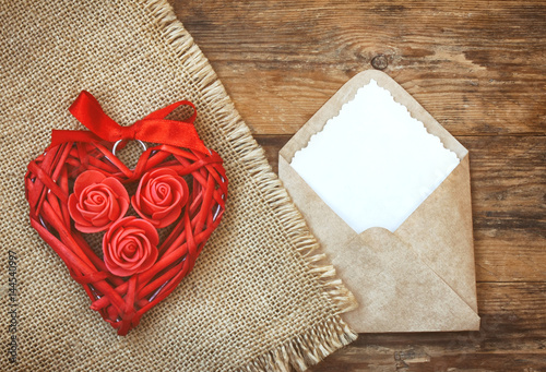 Red wicker heart with roses, ribbon, envelope