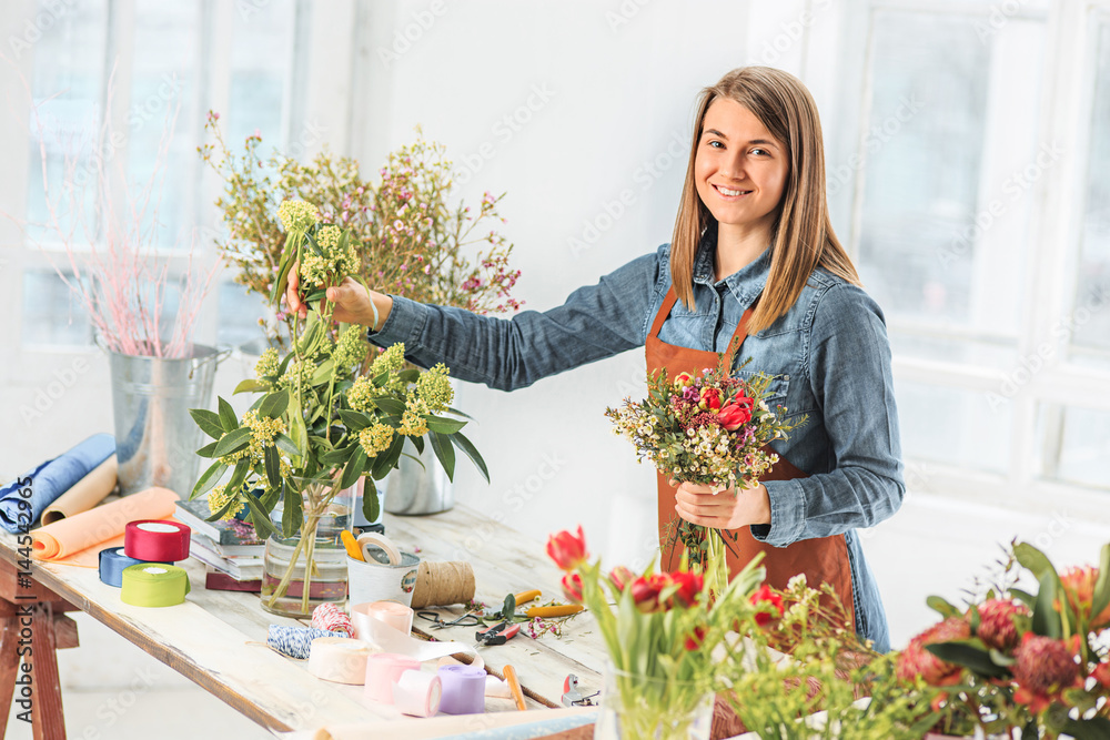 Florist at work: the young girl making fashion modern bouquet of different flowers Florist at work: the young girl making fashion modern bouquet of different flowers