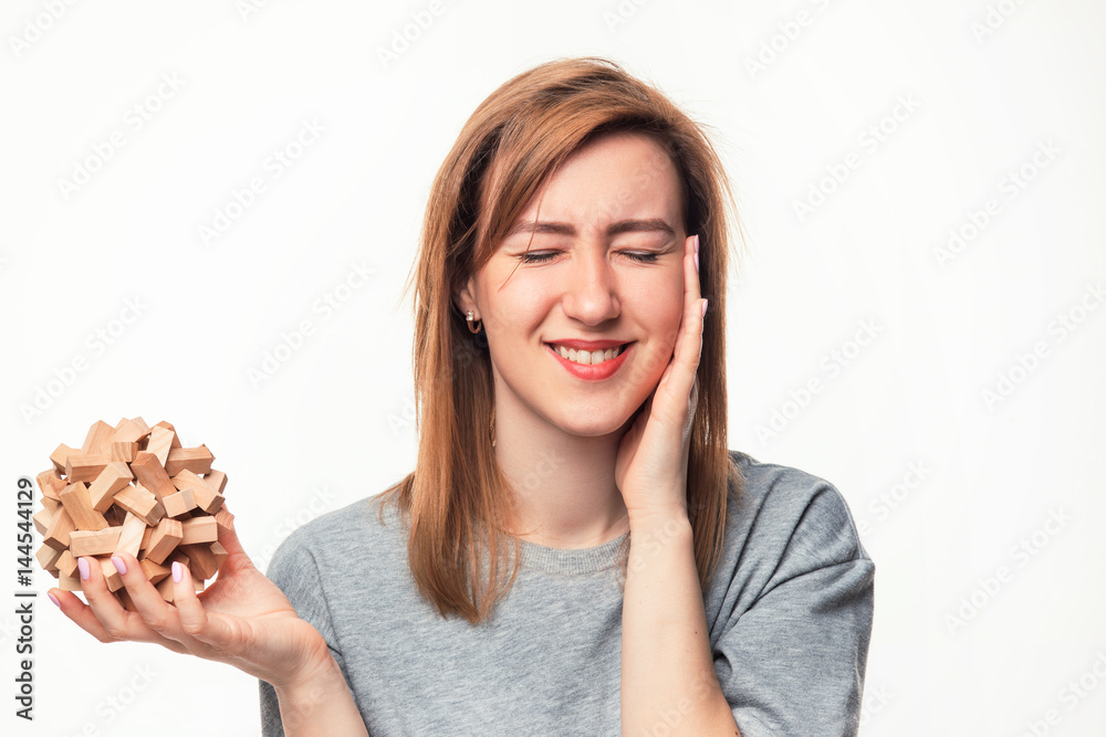 Attractive 24 year old business woman looking confused with wooden puzzle. Attractive 24 year old business woman looking confused with wooden puzzle.