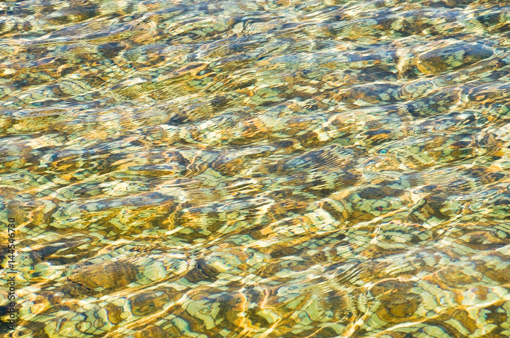 The water in the pool has a tile bottom tile glittering in the sun. Background, texture