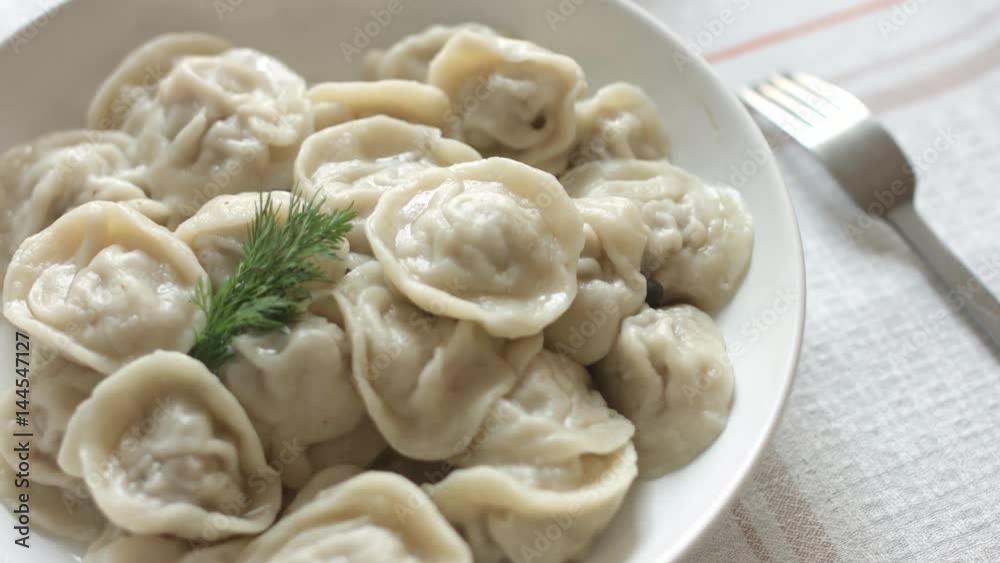 White plate of hot homemade dumplings on the table White plate of hot homemade dumplings on the table