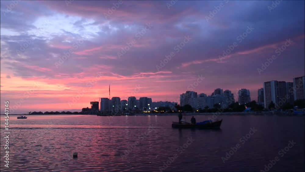 Fishing boat on sea at sunset in Izmir - Turkey. Cloudy sunset sky with accelerated motion. Fishing boat on sea at sunset in Izmir - Turkey. Cloudy sunset sky with accelerated motion.