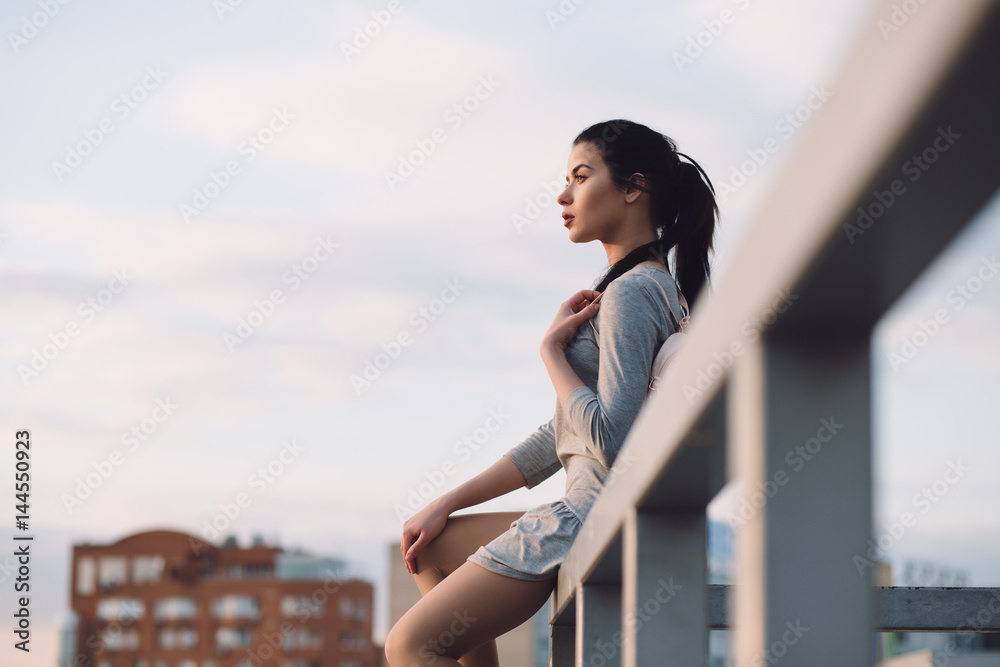 Stylish woman sitting on roof and relaxing