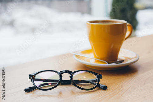 Yellow coffee Cup on the table and glasses