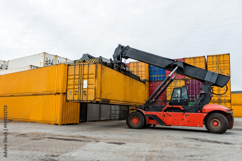 Mobile stacker handler in action at a container terminal. Mobile stacker handler in action at a container terminal.