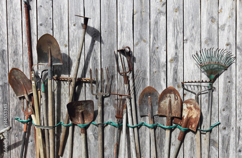 old gardening tools on a wooden background 