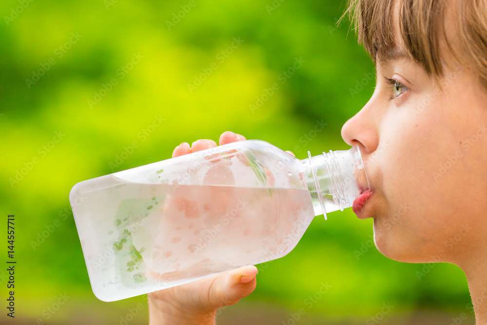 Girl drinking clean tap water from transparent plastic bottle Girl drinking clean tap water from transparent plastic bottle