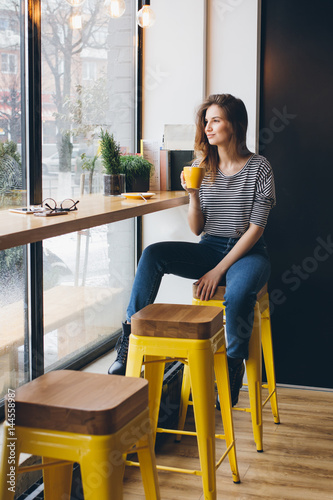 Girl drinking coffee in a coffee shop