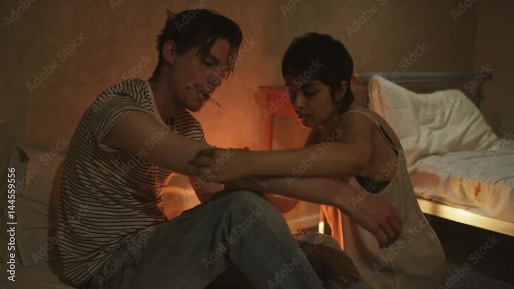 Drug addict couple in gloomy apartment taking heroin together Drug addict couple in gloomy apartment taking heroin together