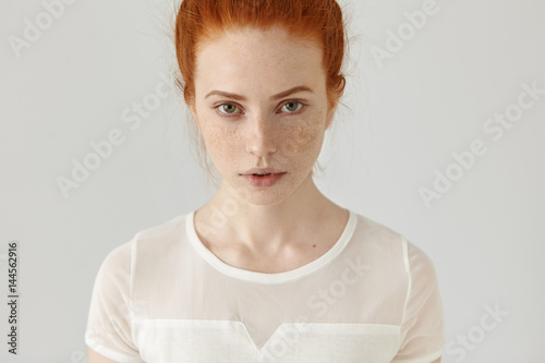 People and lifestyle. Beauty and fashion. Portrait of confident young ginger woman with pretty face standing isolated against blank studio wall background with copy space for your promotional content