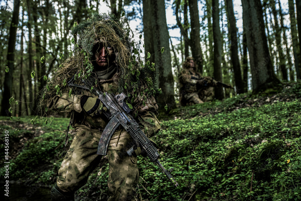 Camouflaged soldier in forest